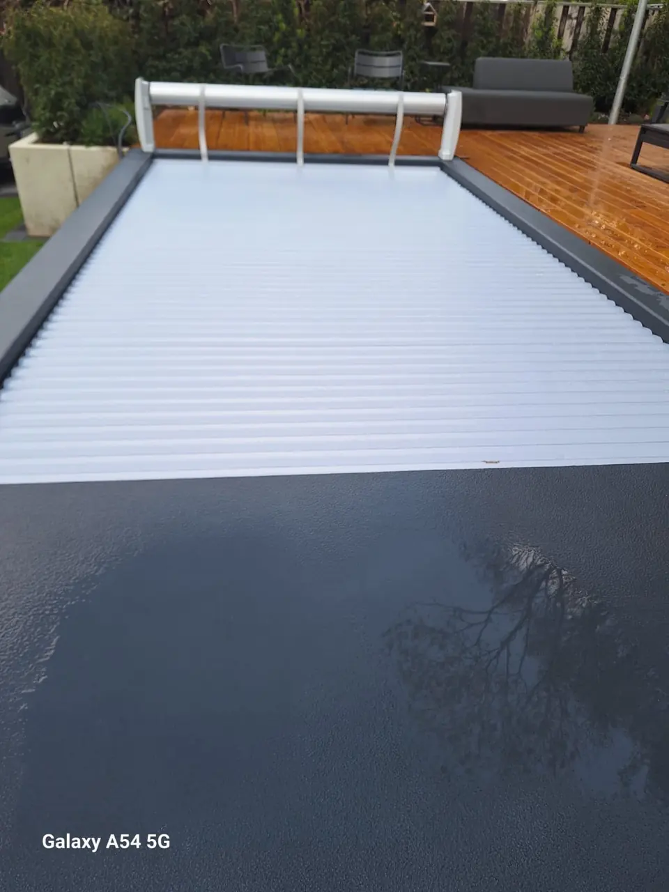 Helle Lamellenabdeckung auf einem dunklen Poolmodul – No1Pool
