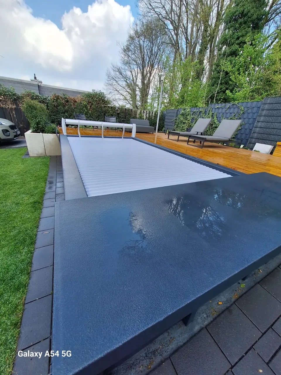 Geschlossene Poolabdeckung neben einer Terrasse – No1Pool
