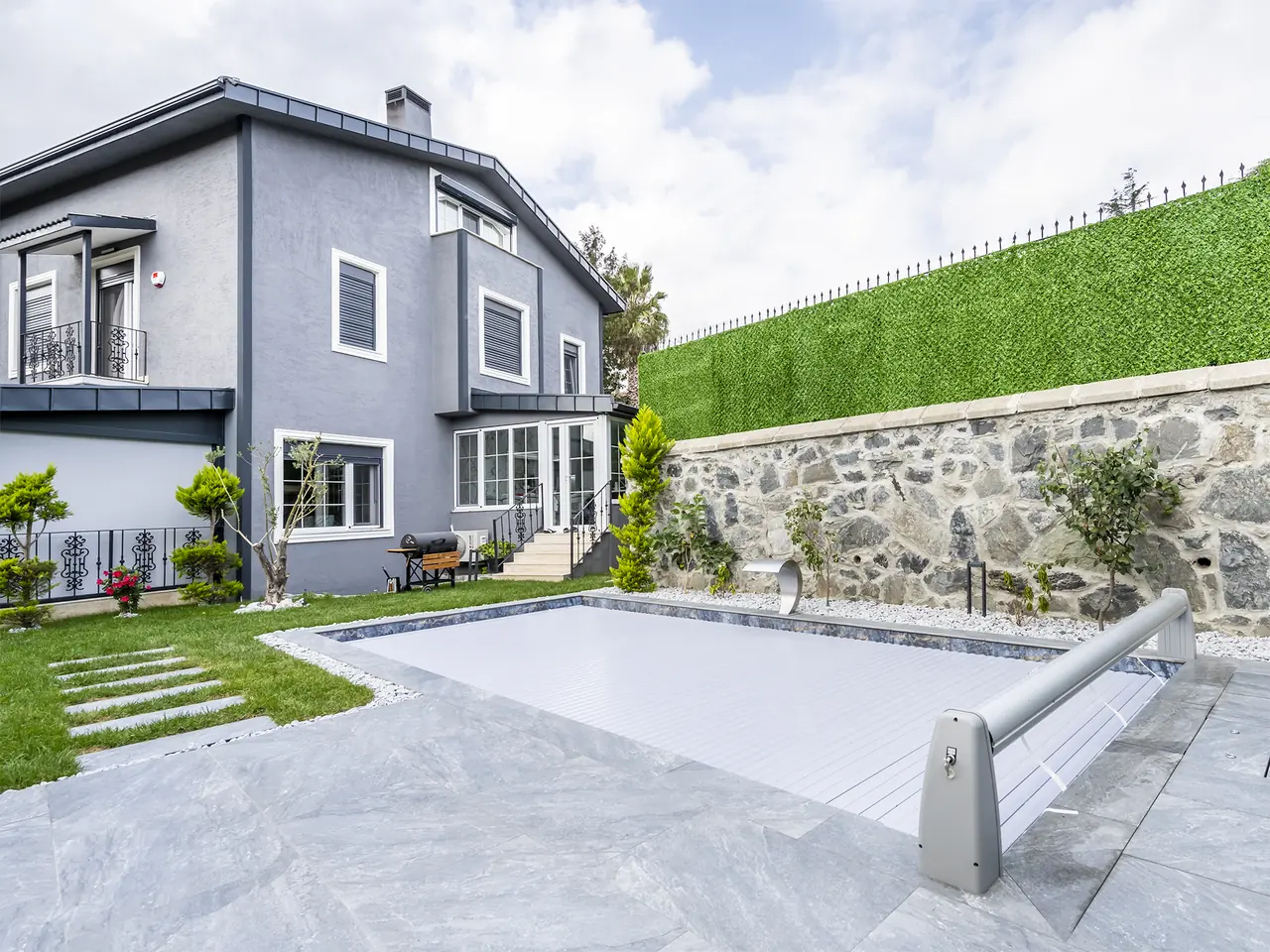 Pool cover and roller mechanism in the garden – No1Pool