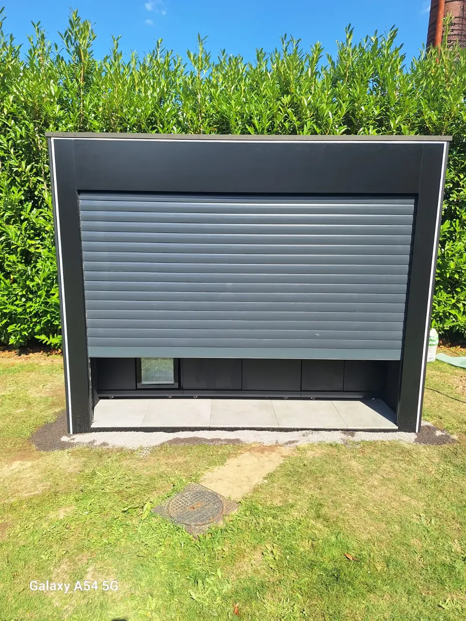 Outdoor-Küchenmodul mit geschlossenem Rollladen im Garten – No1Pool