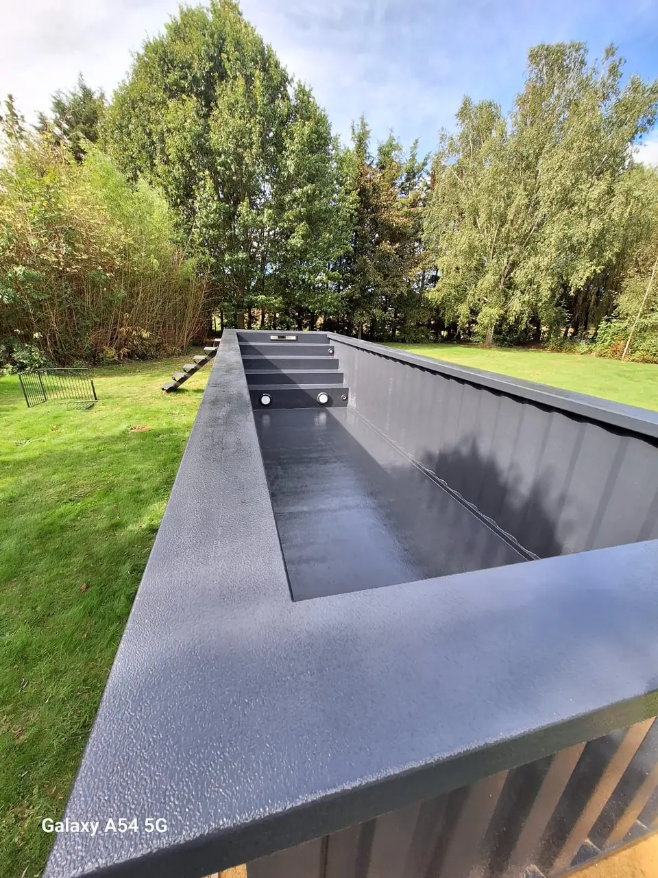 Ungefülltes langes Poolbecken am Gartenrand – No1Pool