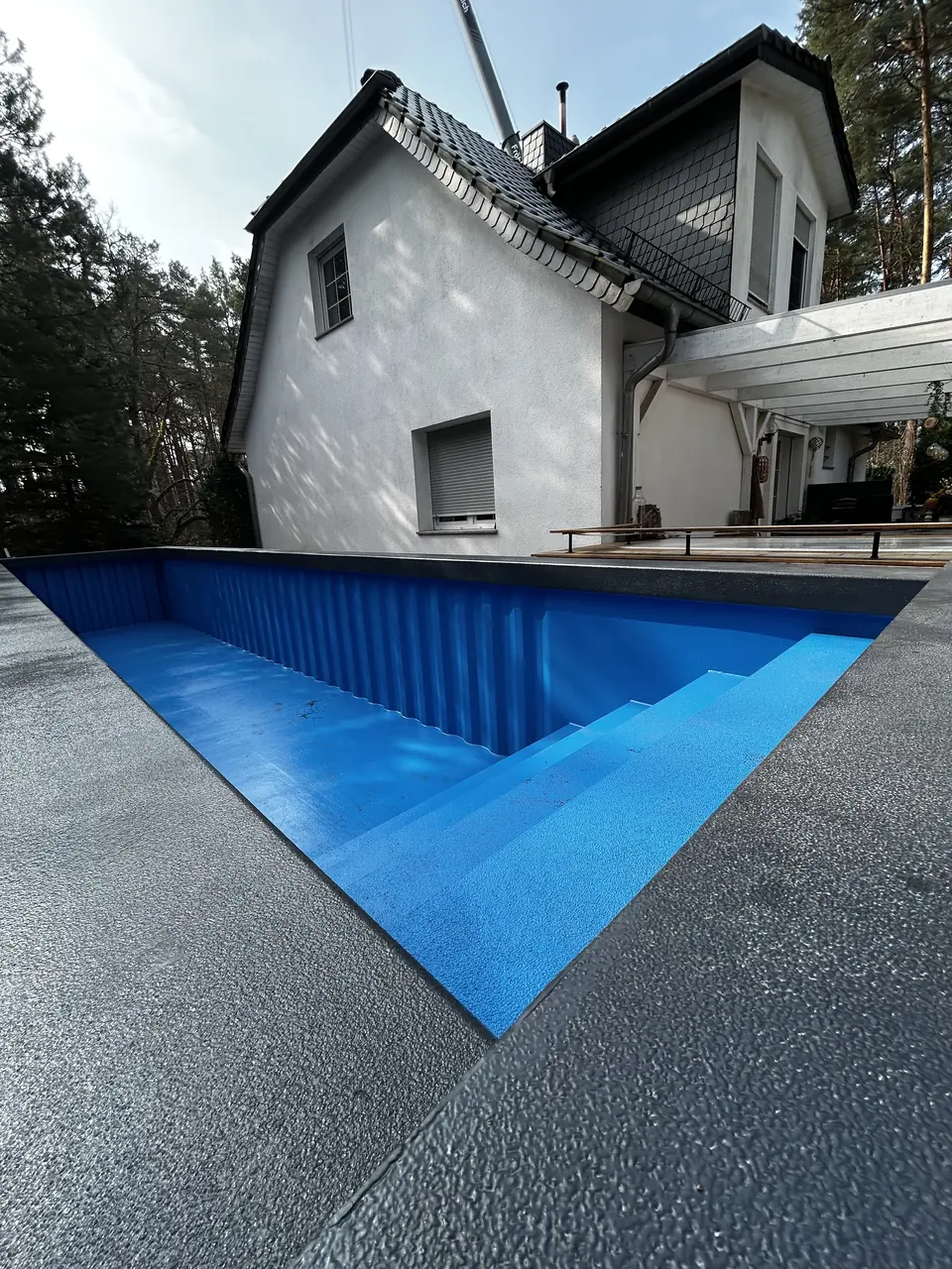 Gefüllter langer Pool zwischen Haus und Terrasse – No1Pool