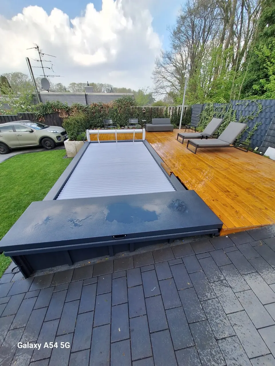 Geschlossene Poolabdeckung neben einer Holzterrasse – No1Pool