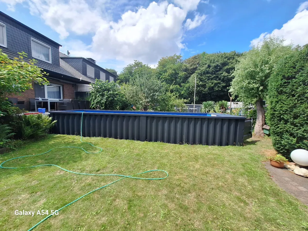 Dunkler Containerpool im Garten eines Wohnhauses – No1Pool