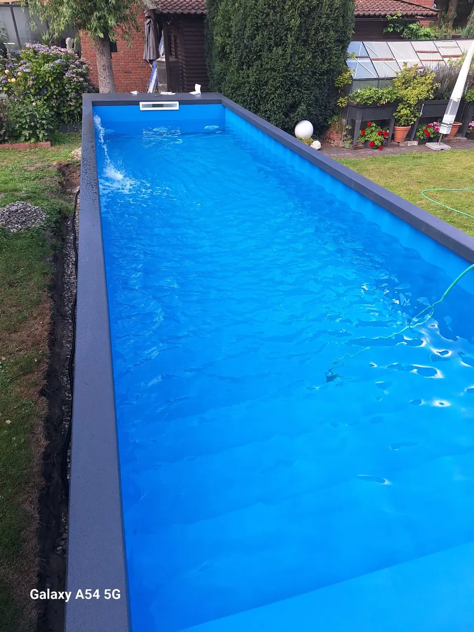 Blick entlang des gefüllten blauen Beckens – No1Pool