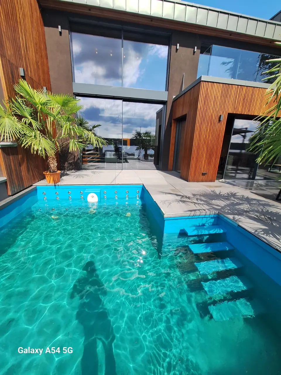 Pooltreppe und Wasserfläche vor einem Holzgebäude – No1Pool