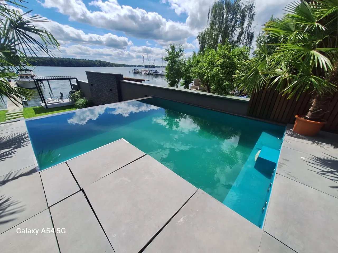 Blick über Terrassenplatten auf den Pool – No1Pool