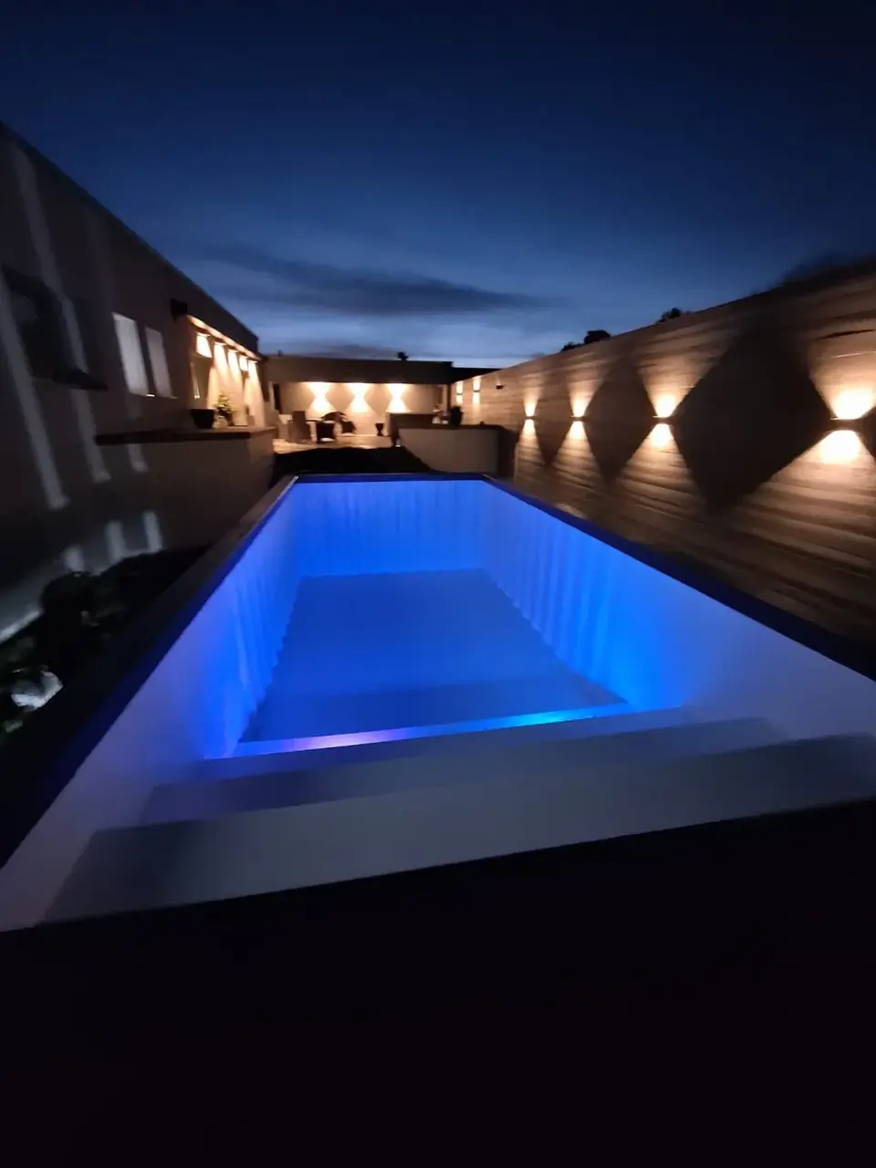 Blau beleuchteter No1Pool im Außenbereich am Abend